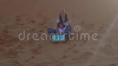 母亲和儿子坐在红色<strong>沙漠里的</strong>雪橇上